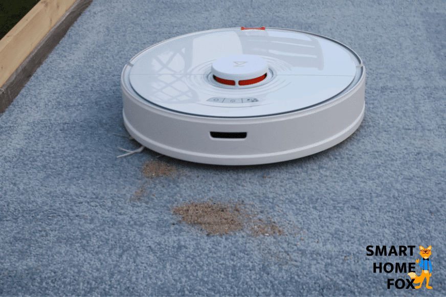 Roborock S7 во время испытания на всасывание песка на ковре с высоким ворсом.